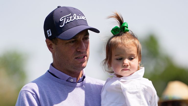 Justin Thomas, left, carries his daughter, Molly Grace, on the first hole during par-3 contest ahead of the Masters golf tournament