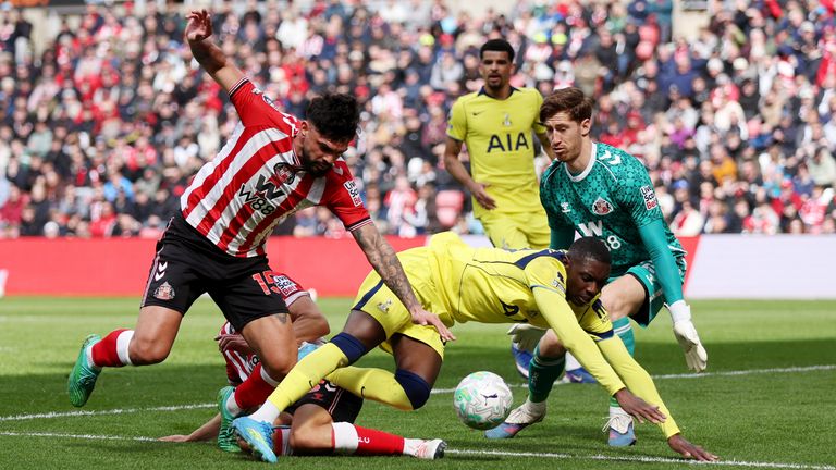 Randal Kolo Muani of Spurs goes down inside the box after a challenge by Sunderland's Luke O'Nien and Omar Alderete