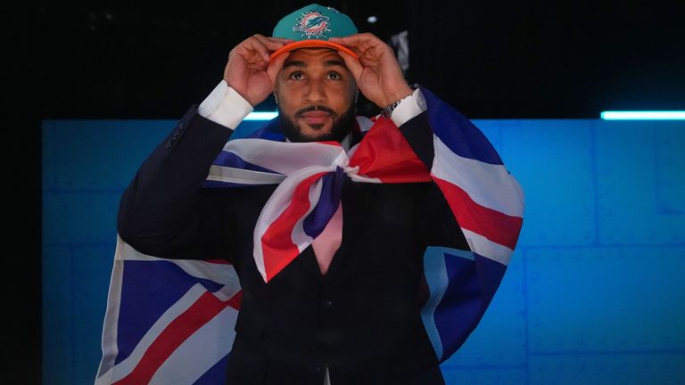 International Player Pathway athlete Seydou Traore puts on a hat after being chosen by the Miami Dolphins with the 180th overall pick during