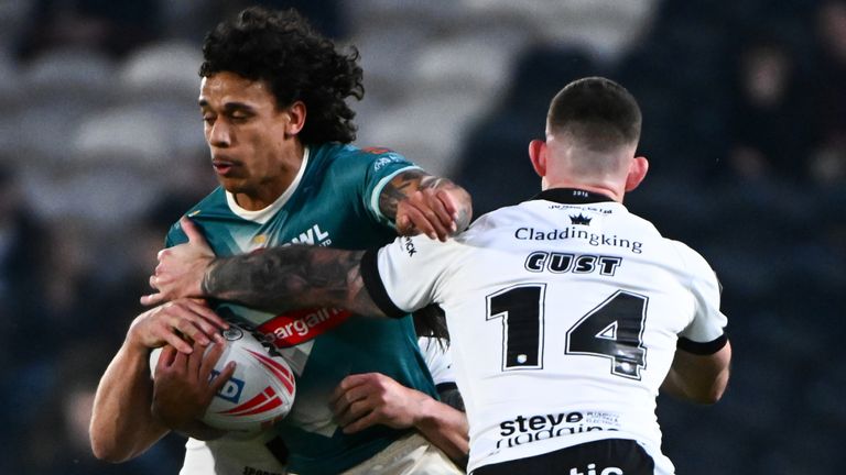 Tristan Sailor of St Helens is tackled by Cade Cust of Hull FC