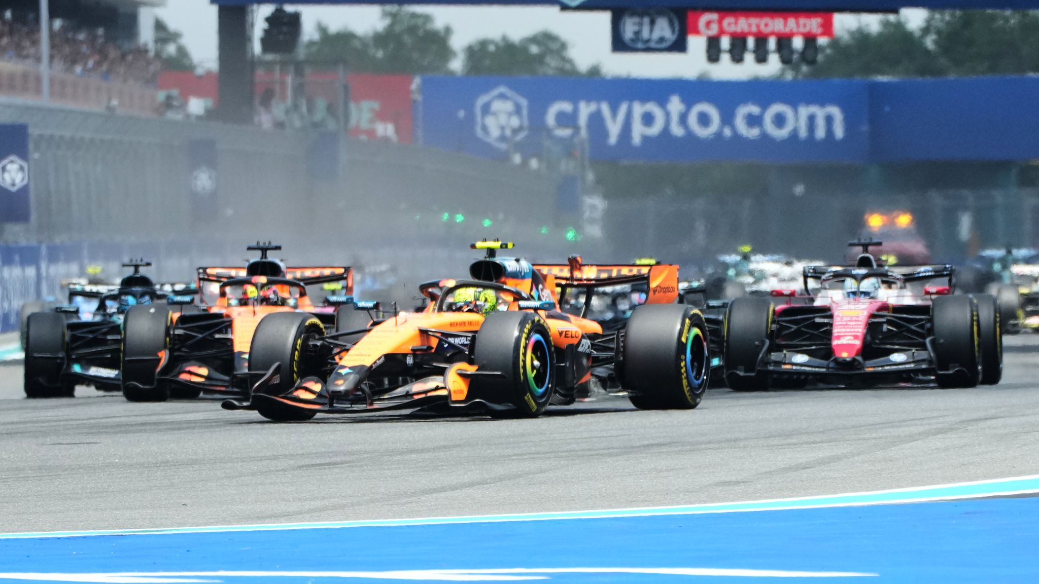 F1 cars racing under cloudy skies