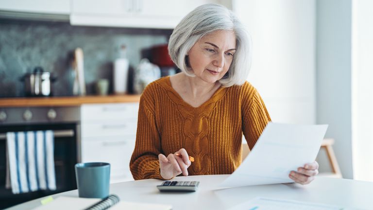 A woman with a calculator and paperwork. Pic: iStock