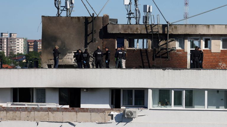 Romanian law enforcement officers work on the site of an explosion at a residential block of flats following a drone hit close to the border
