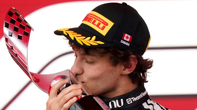 Mercedes'Kimi Antonelli kisses the trophy while celebrating on the podium in Canada (Photo by Geoff Robins / AFP)