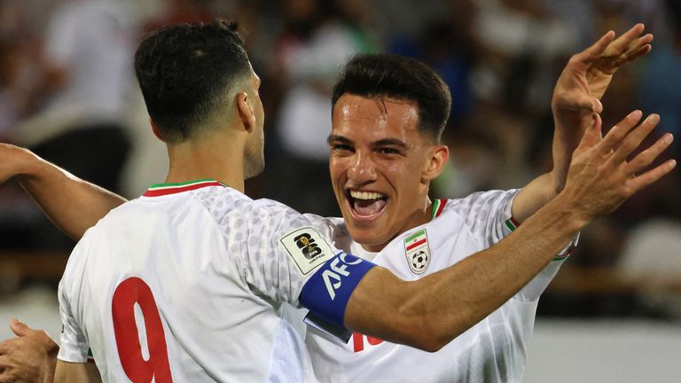 Iran midfielder Amirhossein Hosseinzadeh celebrates with Mehdi Taremi (left) after scoring in qualifying