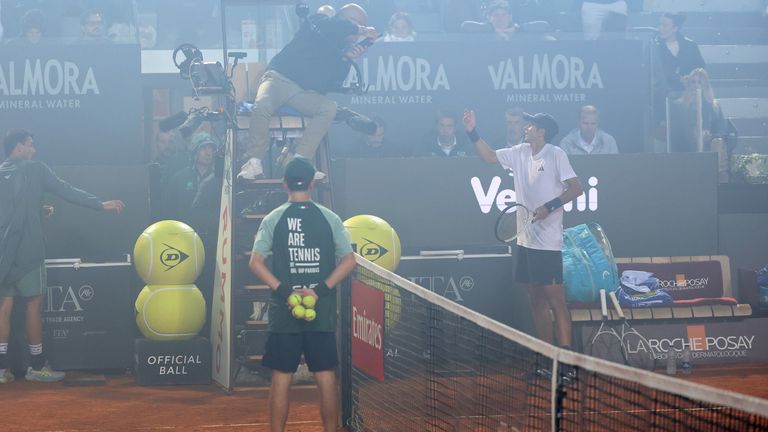 Rafael Jodar  speaks with umpire Manuel Messina as smoke from fireworks at the nearby Coppa Italia final wafts in