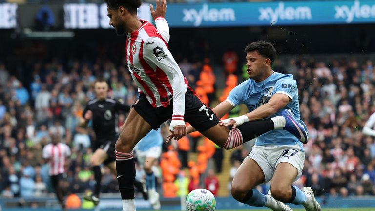Kevin Schade (L) vies with Matheus Nunes (R) during the Premier League match between Man City and Brentford at the Etihad