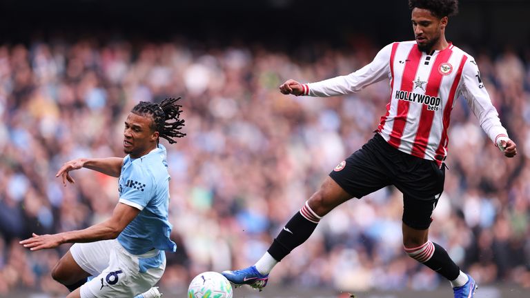 Kevin Schade of Brentford controls the ball as Man City's Nathan Ake slips