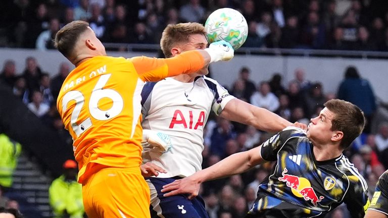 Leeds goalkeeper Karl Darlow punches clear under pressure from Tottenham's Micky van de Ven