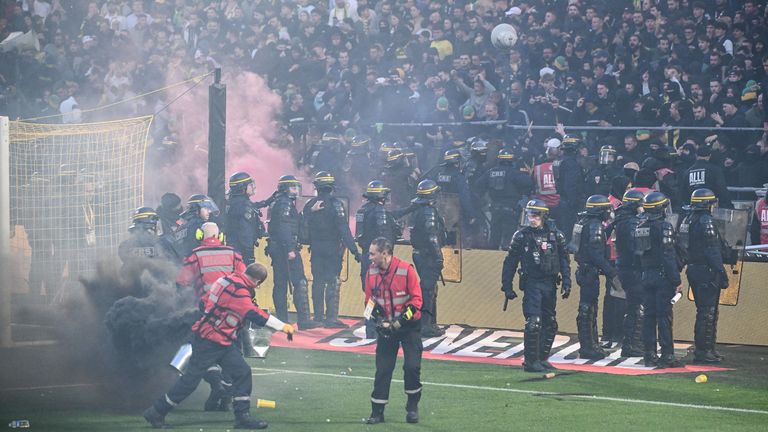 Anti-riot police officers secure the pitch after it was invaded by Nantes' supporters