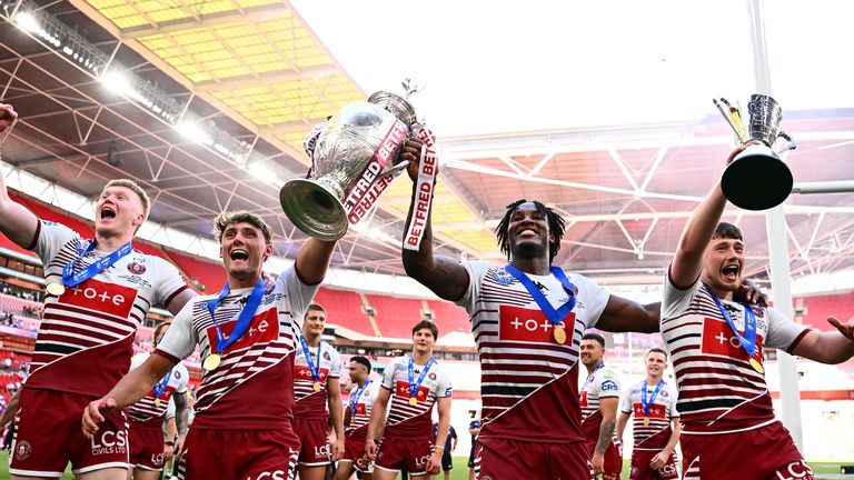 Picture by Olly Hassell/SWpix.com - 30/05/2026 - Rugby League - Betfred Challenge Cup Final - Wigan Warriors v Hull KR - Wembley Stadium, London, England - Wigan's Zack Eckersley, Noah Hodgkinson, Junior Nsemba and Jack Farrimond celebrate to the fans with the Betfred Challenge Cup trophy and Lance Todd Man of the Match trophy after victory over Hull KR.
