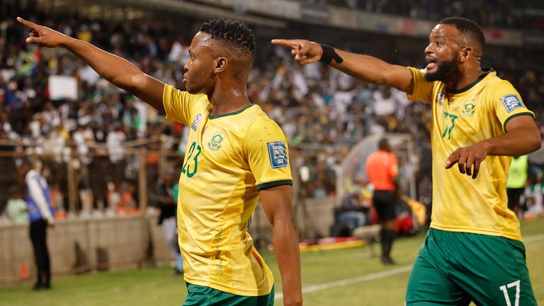 South Africa's midfielder #23 Mohau Nkota (L) celebrates after kicking a ball that lead to Nigeria's own goal during the FIFA World 