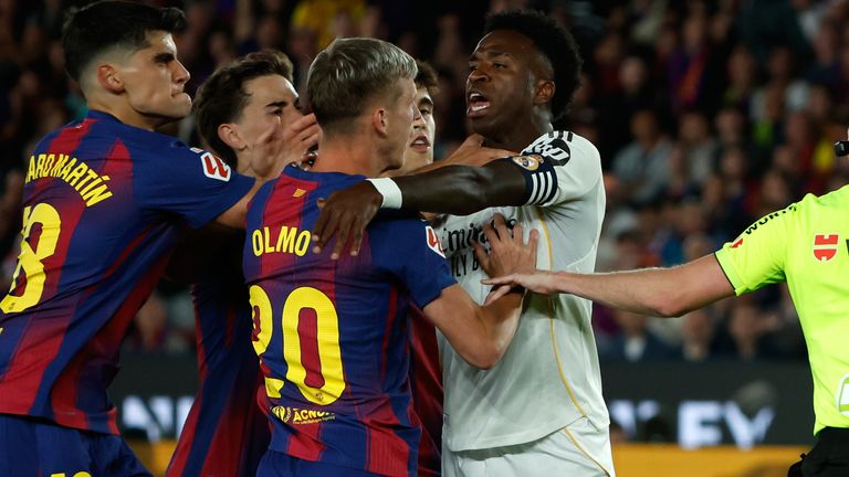 Real Madrid's Vinicius Junior argues with Barcelona players during the Spanish La Liga soccer match between FC Barcelona and Real Madrid in Barcelona, Spain, Sunday, May 10, 2026. (AP Photo/Joan Monfort)