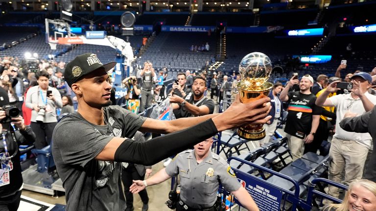 San Antonio Spurs forward Victor Wembanyama walks to Spurs fans as he holds his MVP trophy