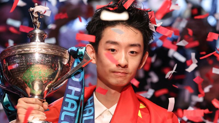 China's Wu Yize poses with the championship trophy after his victory over England's Shaun Murphy in the World Snooker Championship final round at The Crucible in Sheffield, northern England on May 4, 2026. (Photo by Darren Staples / AFP)