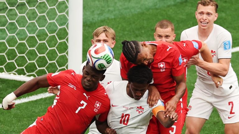 Switzerland's Breel Embolo (7), Canada's Jonathan David (10) and Switzerland's Manuel Akanji (5) battle for the ball