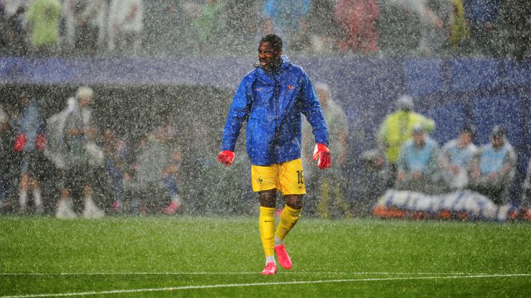 France goalkeeper Mike Maignan warms up as rain falls following a weather delay in the World Cup Group I match between France and Iraq