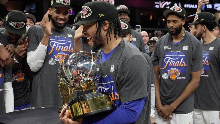 New York Knicks guard Jalen Brunson, center, holds the Eastern Conference Championship trophy after Game 4 in the Eastern Conference finals NBA basketball playoffs series against the Cleveland Cavaliers in Cleveland, Monday, May 25, 2026. (AP Photo/Sue Ogrocki)