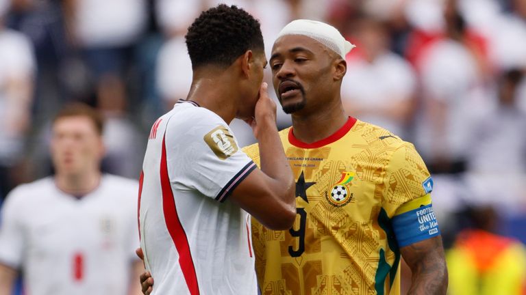 England's Jude Bellingham covers his mouth as he speaks to Ghana's Jordan Ayew
