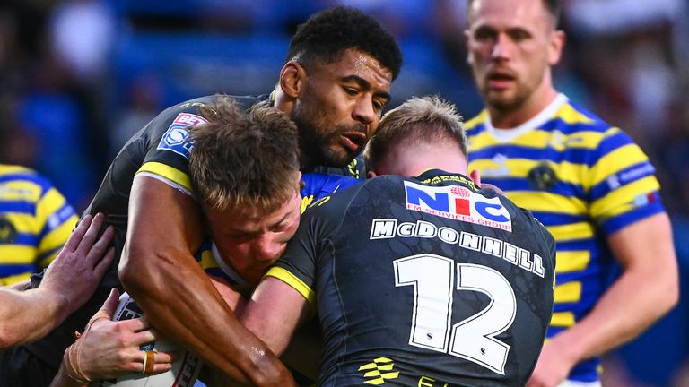 Picture by Olly Hassell/SWpix.com - 18/06/2026 - Rugby League - Betfred Super League Round 15 - Warrington Wolves v Leeds Rhinos - Halliwell Jones Stadium, Warrington, England - Luke Thomas of Warrington is tackled by James McDonnell of Leeds