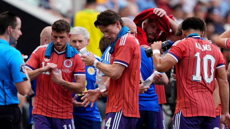 Scott McTominay and the Scotland players cool down during a water break against Bolivia 