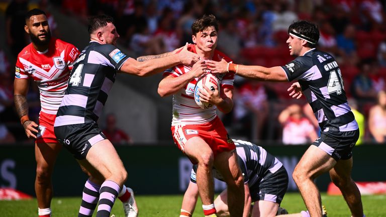 Jack Welsby of St Helens is tackled by Cole Geyer of Huddersfield