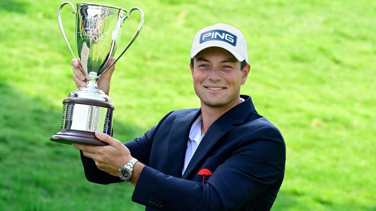 Viktor Hovland holds the Travelers Championship trophy at TPC River Highlands