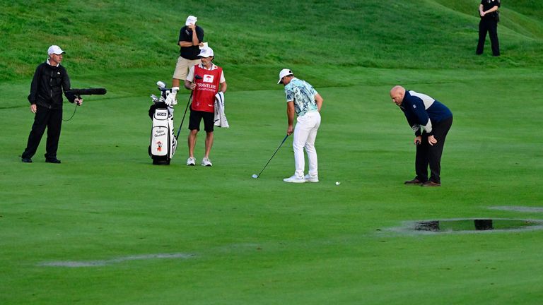 Hovland (centre) receives ruling advice on the 18th fairway