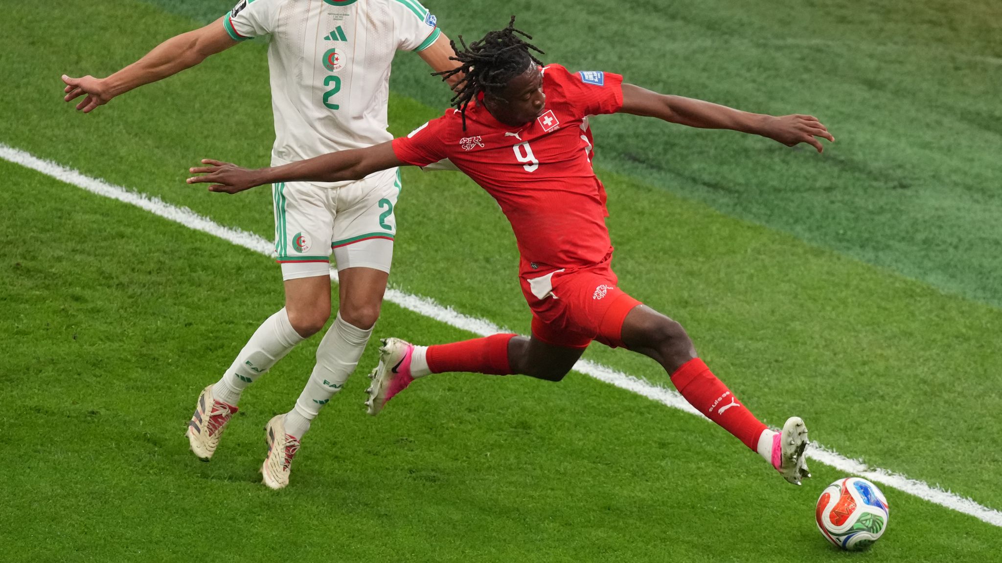Switzerland's Johan Manzambi (9) battles with Algeria's Aissa Mandi (2) during the World Cup round of 32 soccer match betwe