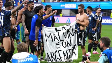 Argentina players hold up a banner with the words 'Las Malvinas son Argentinas' which translates to 'The Malvinas are Argentine'