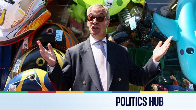 Leader of the Reform UK party Nigel Farage gestures next to a shop, after he announced on Tuesday that he has resigned as an MP, triggering 