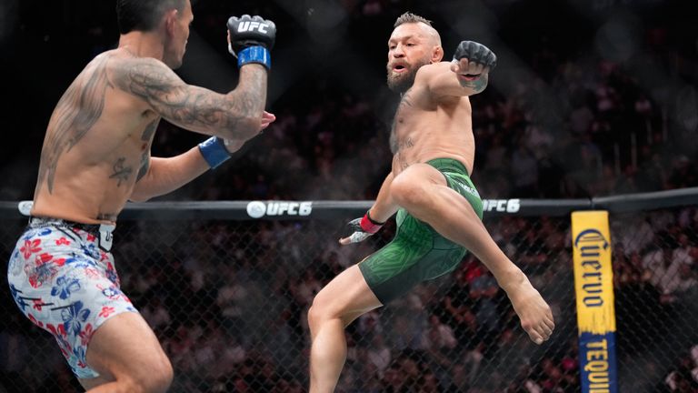 Conor McGregor, right, jumps into the air for a kick as he fights Max Holloway at UFC 329 in Las Vegas. (AP Photo/John Locher)