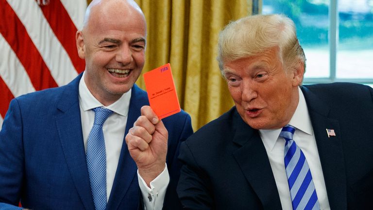 FILE - President Donald Trump holds up a red card during a meeting with FIFA president Gianni Infantino in the Oval Office of the White House, Tuesday, Aug. 28, 2018, in Washington. (AP Photo/Evan Vucci, File)
