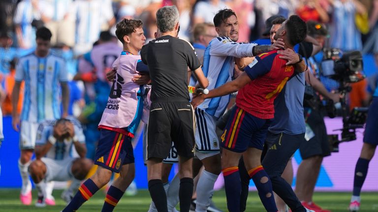 Argentina's Leandro Paredes (5) grabs Spain's Eric Garcia (4) by the neck as assistant referee Tomaz Klancnik, of Slovenia, tries to break up a scuffle after the World Cup final soccer match between Spain and Argentina in East Rutherford, N.J., near 