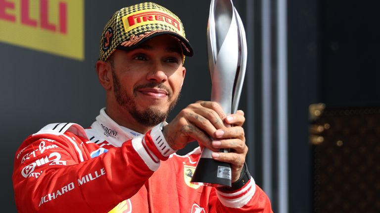 Ferrari driver Lewis Hamilton of Britain holds up his trophy on the podium after placing third after the British F1 Grand Prix, in Silverstone, England, Sunday, July 5, 2026. (AP Photo/Morgan Harlow)