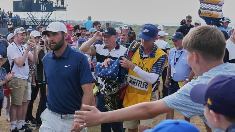 Fans reach out to try and tap hands with Scottie Scheffler of the United States as he walks to the 17th tee during The Open