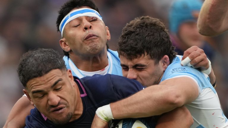 Scotland's Sione Tuipulotu, left, is tackled by Argentina's Faustino Sanchez Valarolo, right, and Gonzalo Garcia