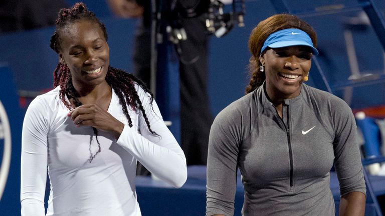 Venus Williams, left, and Serena Williams, of the United States, laugh during an exhibition doubles match at the Rogers Cup in Toronto on Mo
