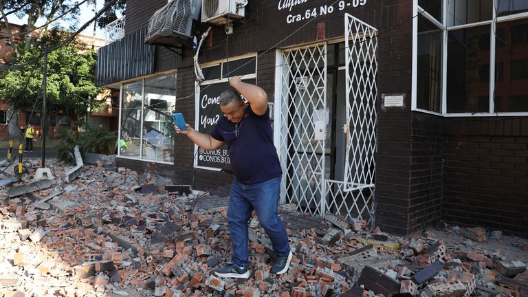 A man leaves an apartment building after an earthquake struck Cali, Colombia, Monday, Aug. 10, 2026. (AP Photo/Santiago Saldarriaga)