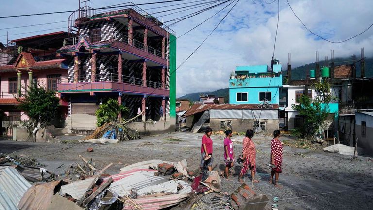 People walk past damage in the aftermath of flash floods in Devighat in the Nuwakot district in Nepal, Thursday, Aug 27, 2026. (AP Photo/Niranjan Shrestha)