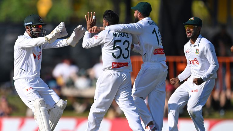 Bangladesh's Mehidy Hasan Miraz, centre, is congratulated by team-mates after his caught and bowled dismissed Steve Smith