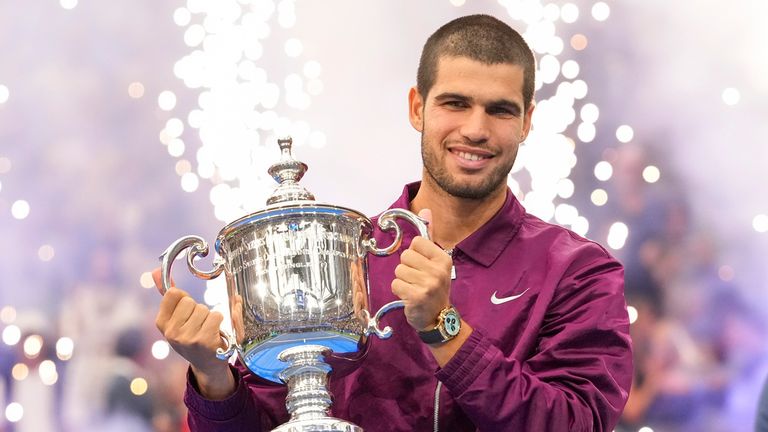Carlos Alcaraz, of Spain, holds up the championship trophy after defeating Jannik Sinner, of Italy, in the men's singles final of the U.S. O
