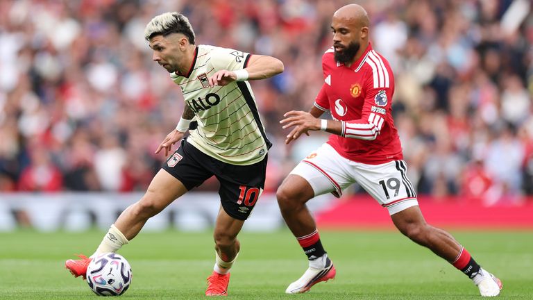 Julio Enciso runs with the ball under pressure from Bryan Mbeumo
