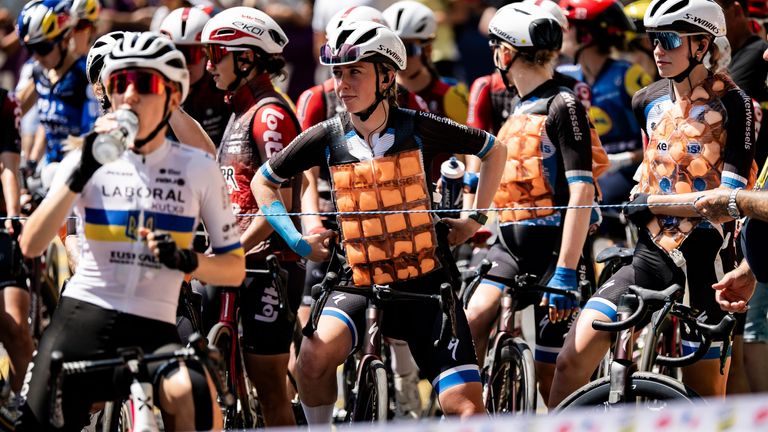 Riders wait for the start wearing cooling vests to beat the heat before the opening stage of the Women's Tour de France (Tour de France Femmes), in Cote de Vullien, Switzerland, Saturday, Aug. 1, 2026. (Jean-Christophe Bott/Keystone via AP)