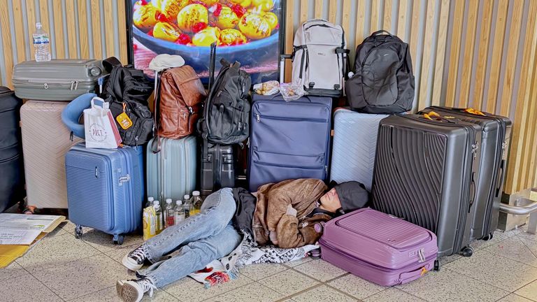 A passenger sleeps on the floor surrounded by luggage at Gatwick Airport in Crawley, West Sussex, during disruption after a system issue hit Nats, which provides air traffic control services to 15 UK airports. Cancellations and delays are expected as
