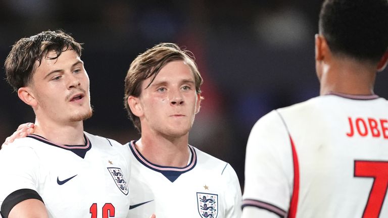 Will Lankshear (left) celebrates scoring England's fourth goal with team-mates Sydie Peck and Jobe Bellingham (right)