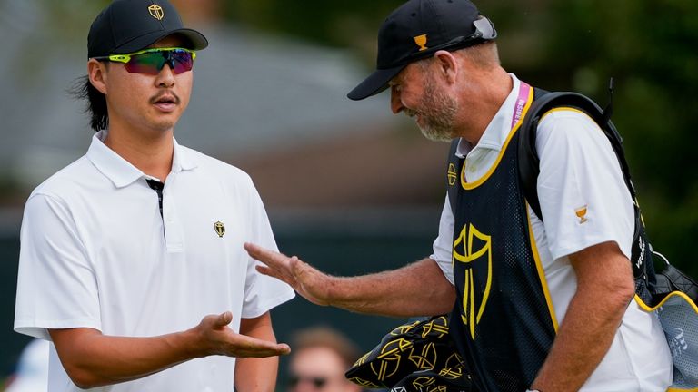 International teams' Min Woo Lee, of Australia, celebrates his birdie on the second hole with his caddie