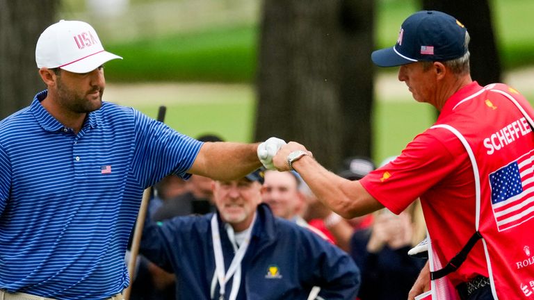 USA teams' Scottie Scheffler celebrates with his caddie on the on the 18th green against the International team