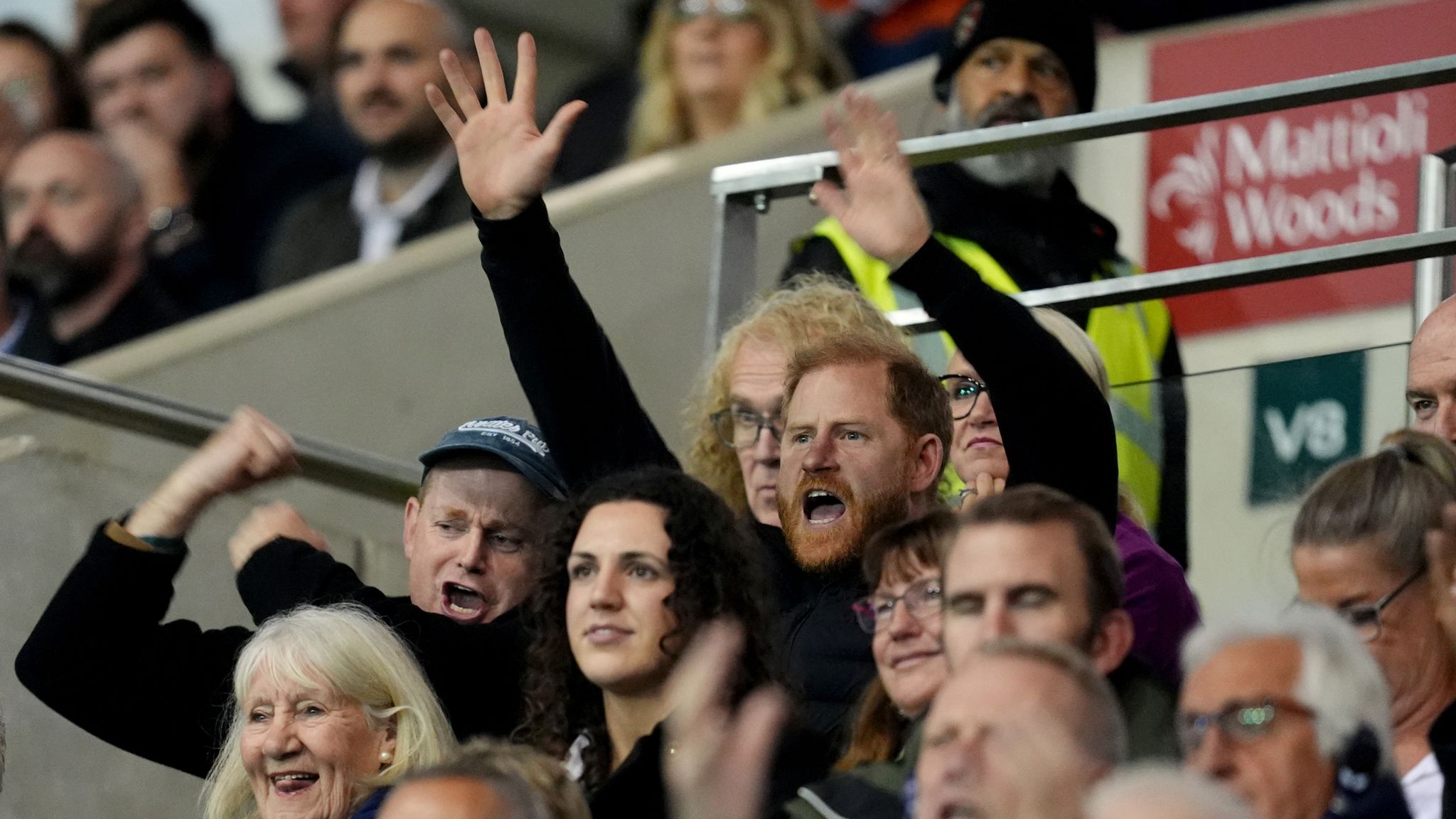 Prince Harry (centre) was spotted in the stands