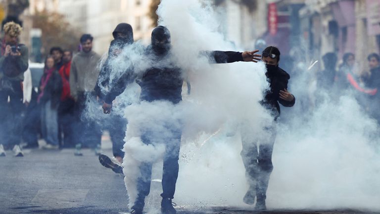 Demonstrators react after tear gas is used in Paris on Sunday. Pic: Reuters